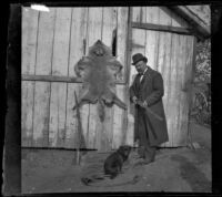 Frank Baynham posing with a rifle, dog and an animal pelt, Pomona, about 1895