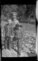 H. H. West, Jr., Keyo and Ambrose Cline posing while standing atop rocks in a stream, San Francisquito Canyon, about 1923