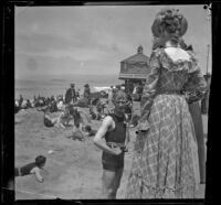 John Duvall and Mary Haas on the beach with the camera obscura in the background, Santa Monica, about 1895