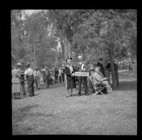 Mertie and H. H. West pose with a "Montgomery" sign while attending the Iowa State Picnic, Los Angeles, 1948