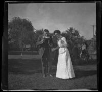 H. H. West and Ellen Lorene (Pinkie) Lemberger stand outside eating fruit, Ottumwa, 1900