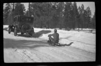 H. H. West, Jr. takes a sled ride on a snowy road, Big Bear, 1932