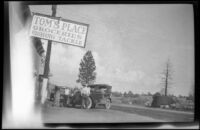 Tom's Place grocery store with 2 cars and 3 people in front, Toms Place, 1929