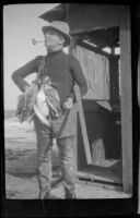 Theodore "Pete" Lohman poses with his rifle and a string of ducks, Seal Beach vicinity, 1920