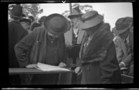 Two women look at a register at the Iowa Picnic in Lincoln Park, Los Angeles, 1939