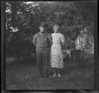 Walter Burgess and Mertie West stand together in a yard, Los Angeles, 1941