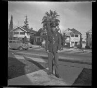 H. H. West Jr. stands in front of the West's home at 2223 Griffin Avenue wearing his army uniform, Los Angeles, 1940