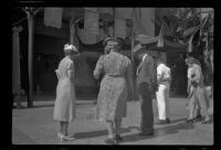 Mertie, Myrtle, and Evert West look at the footprints in the cement in front of Grauman's Chinese Theatre, Los Angeles, 1941