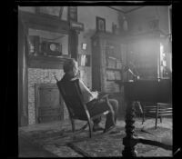 George M. West sits on a rocking chair in the library of the West's house, Los Angeles, about 1898