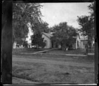 Carl Austin stands in front of his home with his mother and daughters, Red Oak, 1900