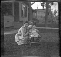 Mary West poses on a front lawn with her daughters, Elizabeth and Frances, Los Angeles, about 1907