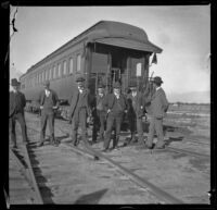 Several Southern Pacific Railroad employees pose in front of a train car, Salton Sea vicinity, about 1899