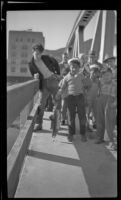 Boy posing with salmon he caught from a bridge, Ketchikan, 1946