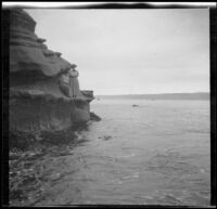 Mary West and Bessie Velzy stand on the rocks next to the ocean at La Jolla, San Diego, 1909