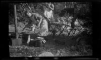 Mertie West and Forrest Whitaker prepare food at their Forest Home campsite, Redlands vicinity, about 1927