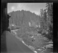 Train traveling through a canyon alongside the Sacramento River, Shasta County, about 1903