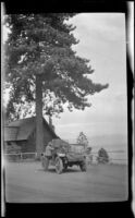 Harry Schmitz stands by H. H. West's Buick on the bank of Lake Tahoe, Lake Tahoe, 1917