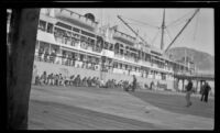 Distant view of Filipino men playing guitar and banjo on the dock, Metlakatla, 1946