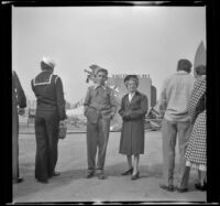 Richard Siemsen and Mertie West pose in front of the plane exhibit at the "Shot from the Sky" exhibition, Los Angeles, 1944