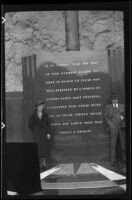 Mertie West and H. H. West pose for a photograph while standing next to an inscribed tablet, Boulder City vicinity, 1939