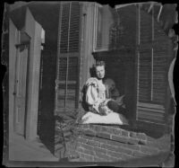 Prostitute sits in the window of a crib on Alameda Street, Los Angeles, 1896