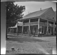 Harry Schmitz and Wilfrid Cline, Jr. stand outside the Tower House hotel, Shasta County, 1917