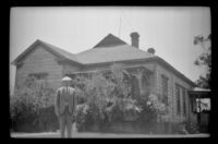 Wilson West stands in front of 1919 North Hancock Street, Los Angeles, 1936