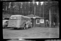 Mertie West poses beside the touring bus at Johnston Canyon, Banff National Park, 1947