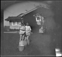 Elizabeth and Frances West stand in a washboiler in the backyard of the West's house, Los Angeles, about 1914