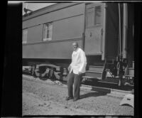 Old Methuslia, a Pullman porter, stands beside the train, Mount Shasta vicinity, 1947