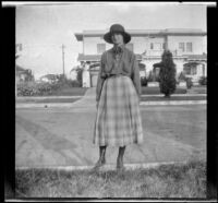 Lois Winkler stands on a curb and poses in front of her family's home, Los Angeles, about 1918