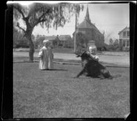 Daugherty brothers play with Guy West's dog, Los Angeles, 1897