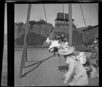 Girls play on a swings with the North Beach Bath House at the right, Santa Monica, about 1895