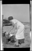 Mertie Whitaker cooking on the beach near Rincon Point, Carpinteria vicinity, about 1924