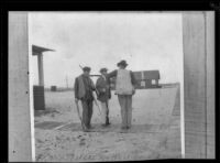 Frank Siefert, Guy West, and E. C. "Dick" Taylor stand in front of the West's beach cottage holding guns, Venice, about 1903