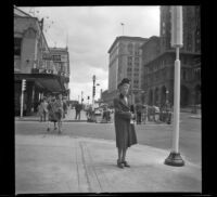 Mertie West stands on a street corner in front of the second Hotel Vancouver, Vancouver, 1947