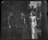 Daisy Conner and one of the Bendixon sisters watch the other sister blow up a balloon, Los Angeles, about 1900