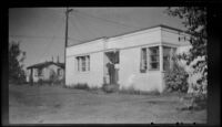 H. H. West poses in front doorway of Kinsell's home, Anchorage, 1946