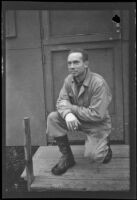 H. H. West, Jr. kneels and poses in front of his barracks at Fort Mears (negative), Dutch Harbor, 1942