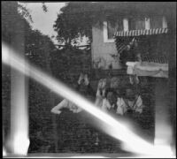 Elizabeth and Frances West pose in the backyard of the West's home with their cousin, Frances Cline and unknown boy, Los Angeles, about 1914