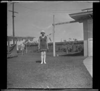 Frances West stands in the West's backyard wearing a bathing suit, Los Angeles, about 1920