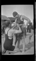 H. B. Powell helps dress up Miss Love as a hula dancer, Hermosa Beach, about 1932