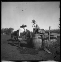 H. H. West watches William Mead fill a water barrel, Elliott vicinity, 1900