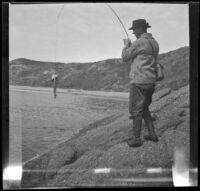Glen Velzy reels in a fish, Laguna Beach, 1914