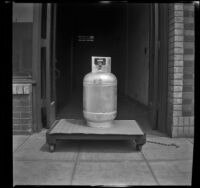 Tall gas tank sitting atop a dolly outside the H. H. West Company offices on Omar Avenue, Los Angeles, 1946