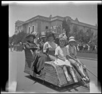 Christina Schmitz, H. H. West, Minnie West, Frances Cline and Elizabeth West riding an Osborn Electriquette along El Prado in Balboa Park, San Diego, [about 1915]