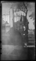 Mertie West poses beside a tablet on the gate of Copp's Hill Burying Ground, Boston, 1947