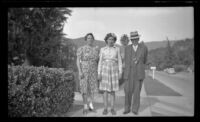 Elizabeth Siemsen, Dorothea Siemsen and H. H. West pose on a sidewalk in front of the Siemsen's residence, Glendale, 1943