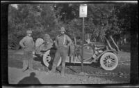 Wilfrid Cline, Jr. and Harry Schmitz standing by a road sign and H. H. West's Buick, Cisco, 1917