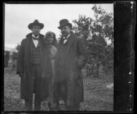 Bim Smith, Pearl Smith and Frank Baynham posing in an orange orchard, Pomona, about 1895